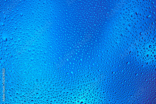 Drops of water on a glass with a color gradient.