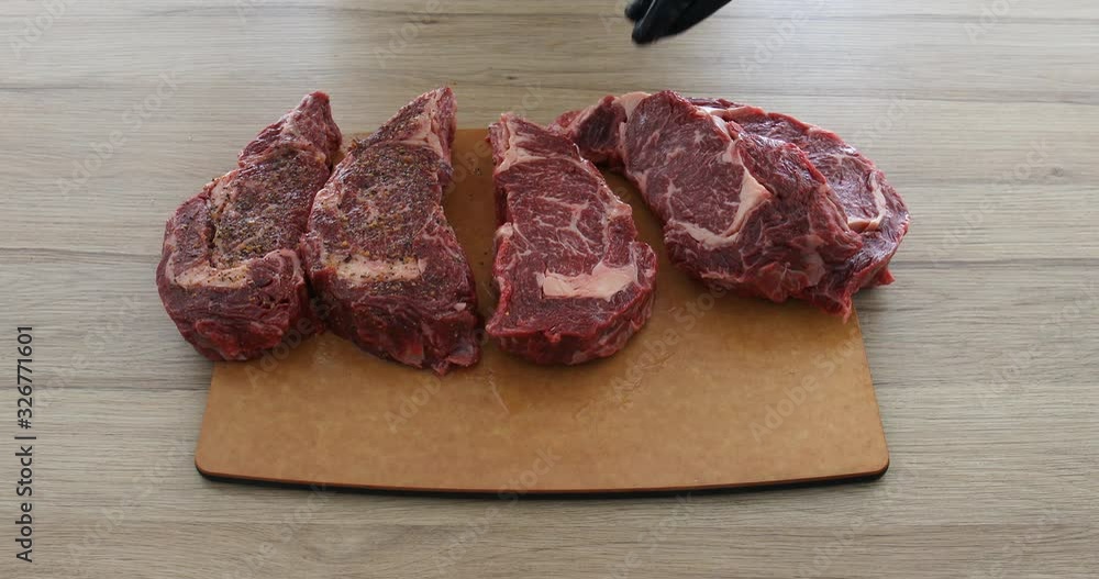 Cook sliced beef steaks ribeye with knife watering butter and sprinkling spices Cook sliced beef steaks ribeye with knife watering butter and sprinkling spices
