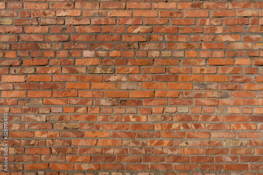 Naklejka premium Old repaired weathered brick wall for background. 