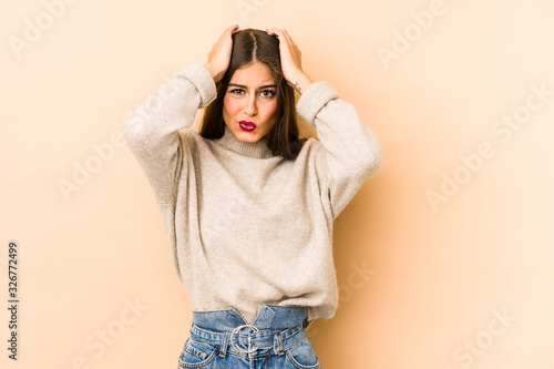 Young caucasian woman isolated en beige background being shocked, she has remembered important meeting.