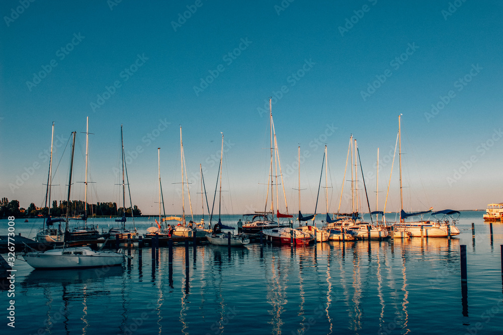 A yacht or boat sails in the sea or ocean. Blue calm sea, beautiful sky. Screen saver, background, or postcard.