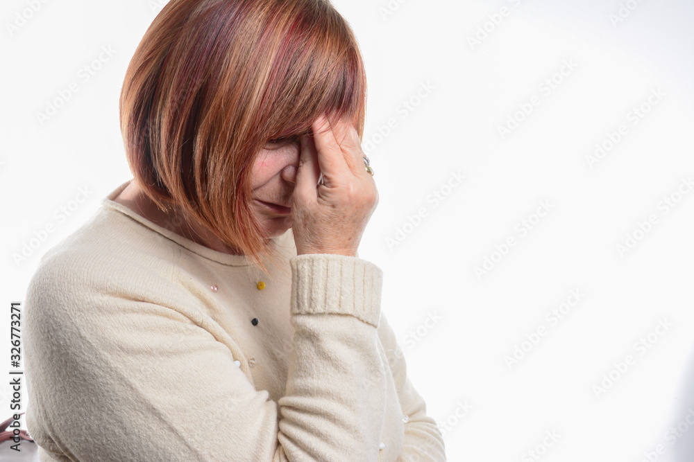 Portrait of an attractive senior woman with a headache. Feeling pain and with an expression of being unwell. Healthcare and migraine concept Portrait of an attractive senior woman with a headache. Feeling pain and with an expression of being unwell. Healthcare and migraine concept