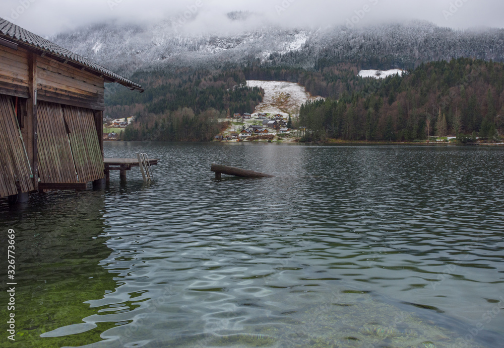 Small picturesque austrian village and Grundlsee, the largest lake in Styria, Austria, set in the wonderful mountain landscape, in misty winter morning