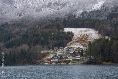 Small picturesque austrian village and Grundlsee, the largest lake in Styria, Austria, set in the wonderful mountain landscape, in misty winter morning photo