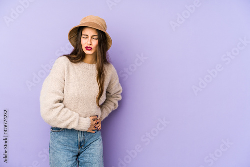 Young caucasian woman isolated on purple background having a liver pain, stomach ache.