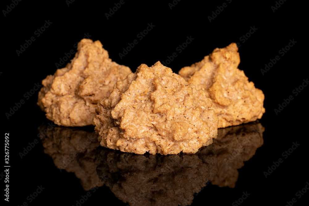 Group of three whole homemade brown coconut biscuit with chocolate isolated on black glass Group of three whole homemade brown coconut biscuit with chocolate isolated on black glass