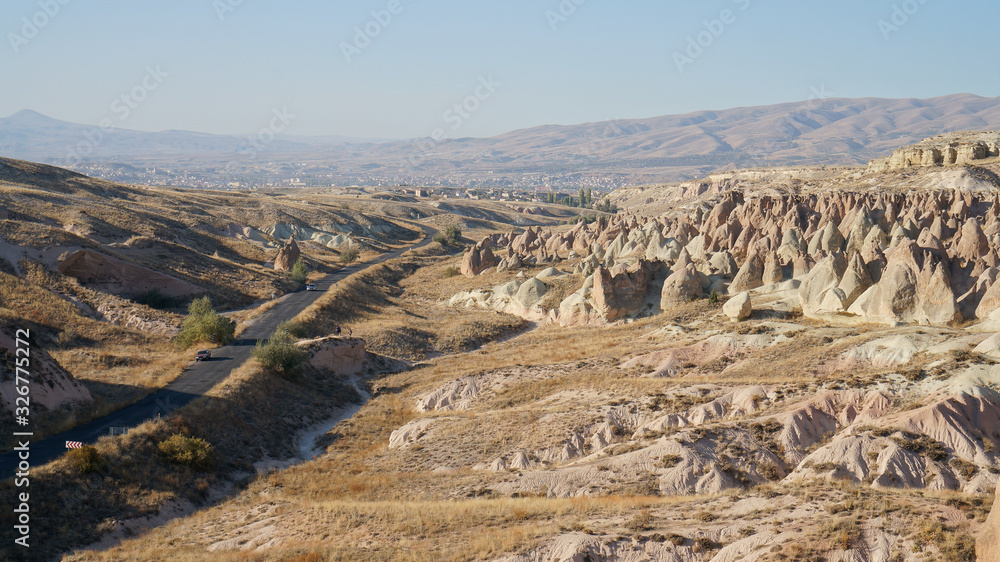 Road and desert landscape with beautiful rocks in Cappadocia, Anatolia, Turkey.