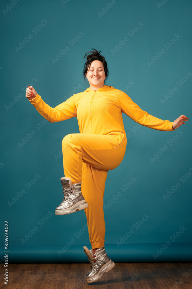 Happy plus size positive woman. Happy body positive concept. I love my body. Attractive overweight woman dressed in a yellow suit fun posing for the camera