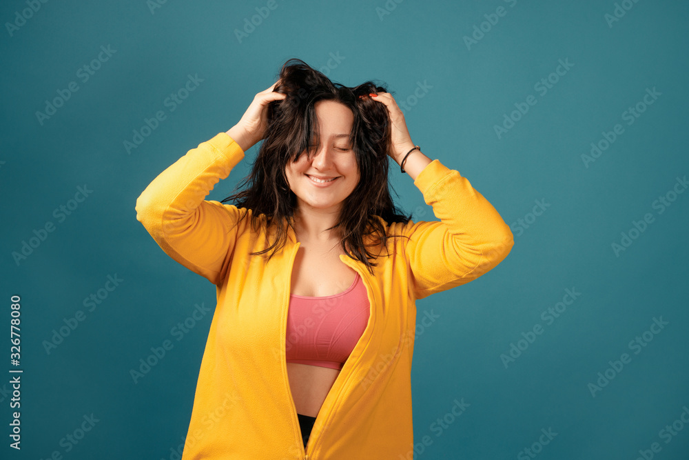 Happy plus size positive woman. Happy body positive concept. I love my body. Attractive overweight woman dressed in a yellow suit fun posing for the camera and scratching her head Happy plus size positive woman. Happy body positive concept. I love my body. Attractive overweight woman dressed in a yellow suit fun posing for the camera and scratching her head