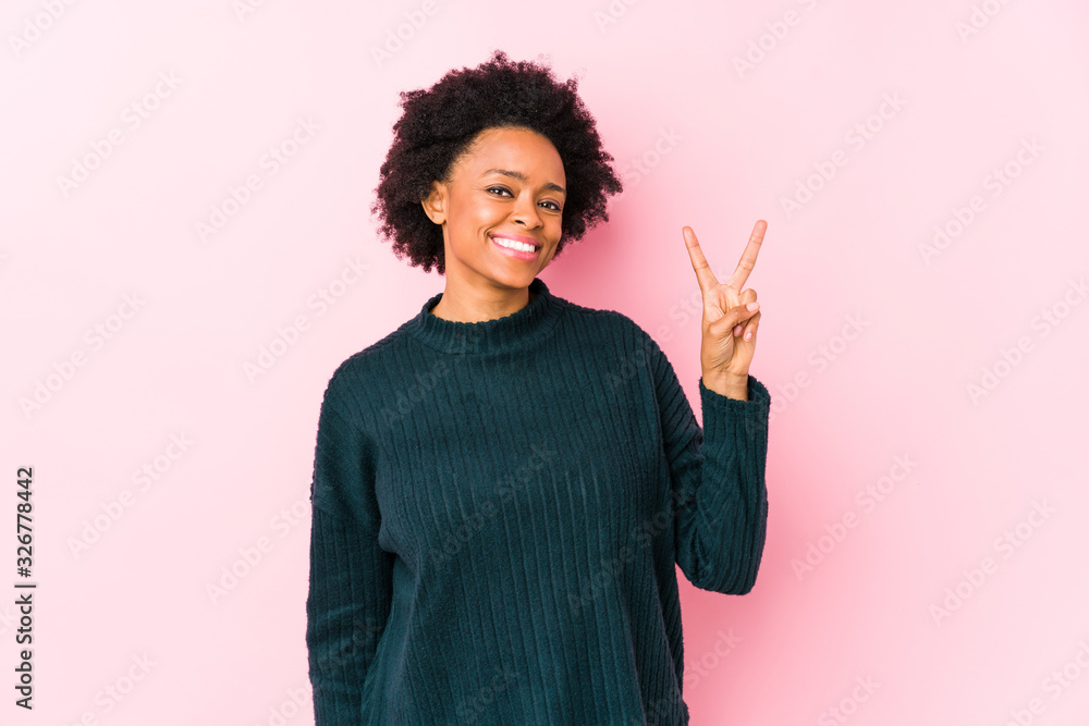 Middle aged african american woman against a pink background isolated showing number two with fingers. Middle aged african american woman against a pink background isolated showing number two with fingers.