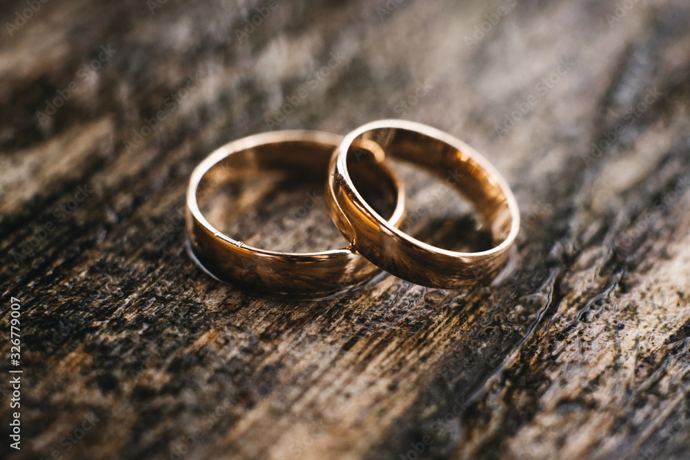 Wedding rings on a beautiful wooden texture surface closeup Wedding rings on a beautiful wooden texture surface closeup