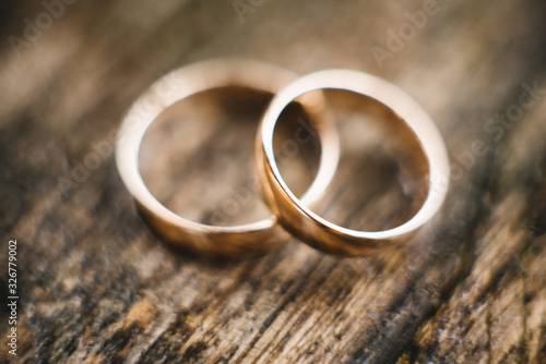 Wedding rings on a beautiful wooden texture surface closeup