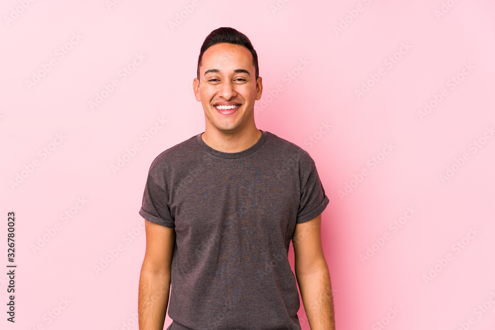 Yooung latin man posing in a pink backgroundhappy, smiling and cheerful. Yooung latin man posing in a pink backgroundhappy, smiling and cheerful.
