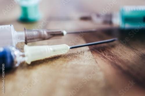 Syringe with cannula on a wooden table with medicine
