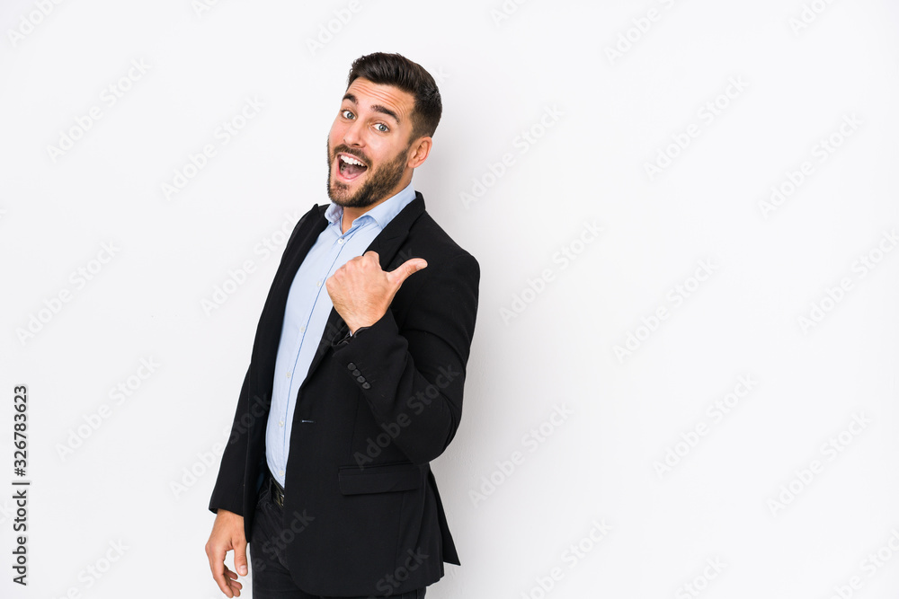Young caucasian business man against a white background isolated points with thumb finger away, laughing and carefree. Young caucasian business man against a white background isolated points with thumb finger away, laughing and carefree.
