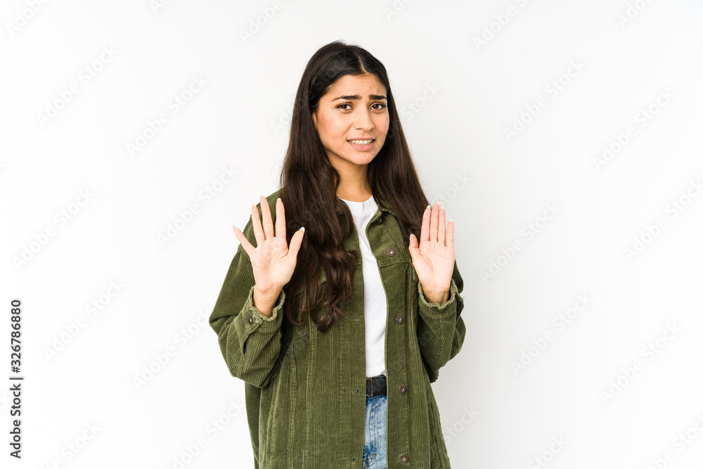 Young indian woman isolated on purple background rejecting someone showing a gesture of disgust. Young indian woman isolated on purple background rejecting someone showing a gesture of disgust.