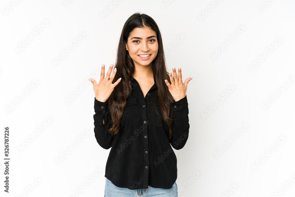 Young indian woman isolated on purple background showing number ten with hands. Young indian woman isolated on purple background showing number ten with hands.
