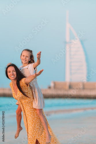 Photography Beautiful mother and daughter at the beach enjoying summer vacation