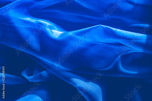 background image of a blue light translucent fabric with pleats. the view from the top.