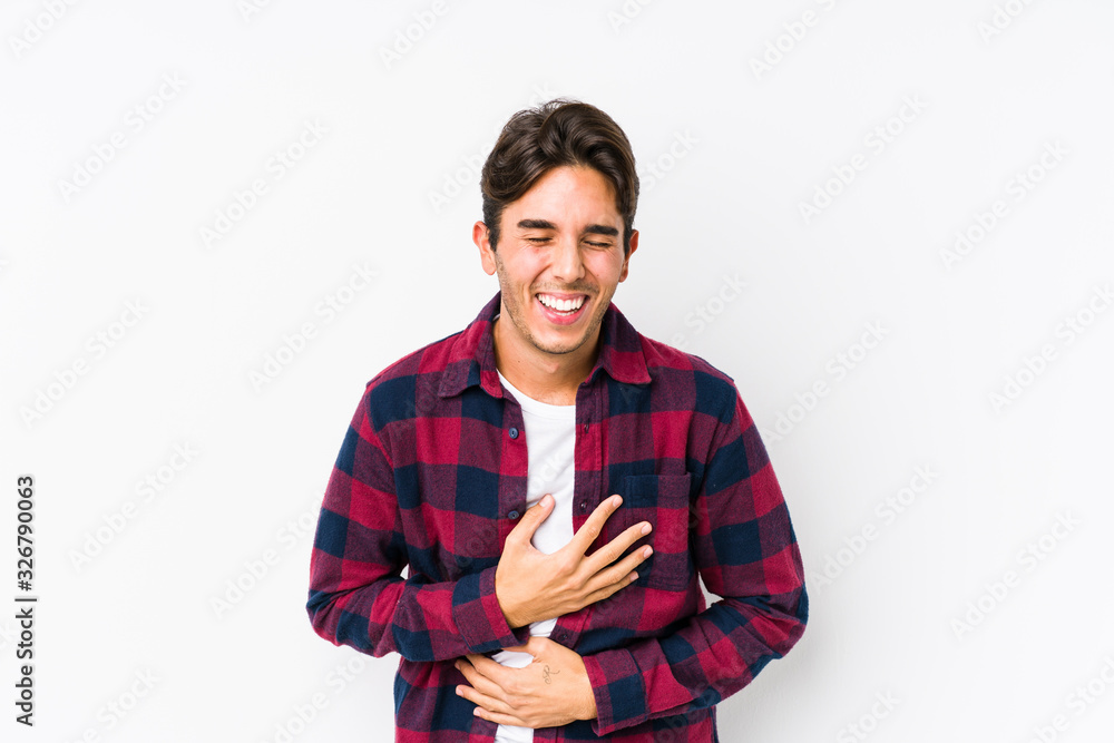 Young caucasian man posing in a pink background isolated laughs happily and has fun keeping hands on stomach. Young caucasian man posing in a pink background isolated laughs happily and has fun keeping hands on stomach.