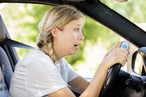 a female sneezing while driving © auremar
