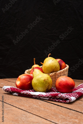 Canasta de frutas, peras y durasnos