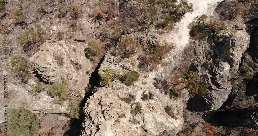 Aerial descend down to active walking girl from the top of sandstone cliff in Australian Blue Mountains. Aerial descend down to active walking girl from the top of sandstone cliff in Australian Blue Mountains.