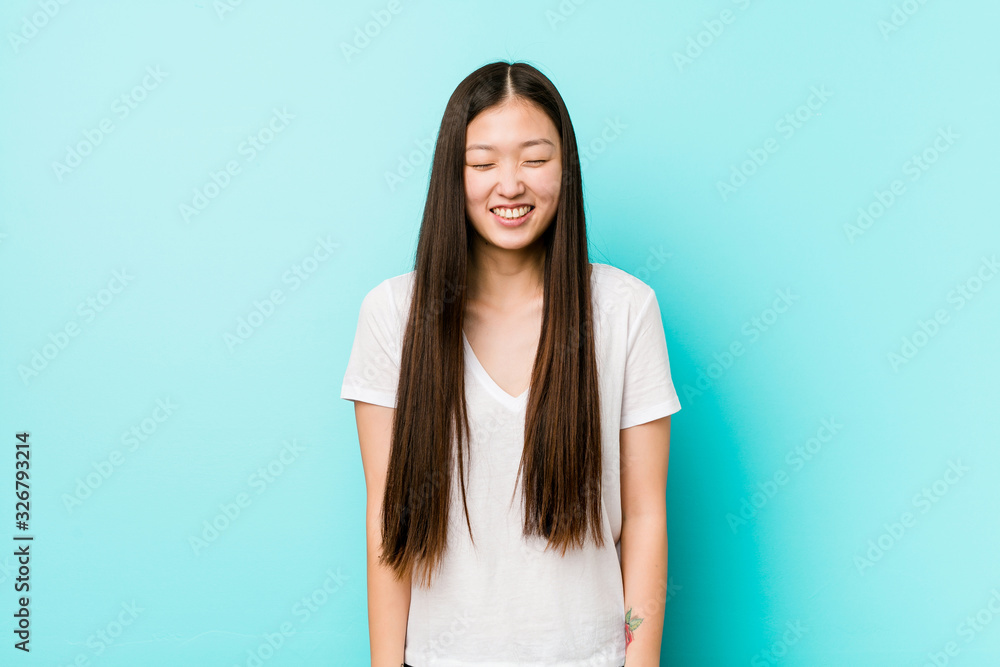 Young pretty chinese woman laughs and closes eyes, feels relaxed and happy. Young pretty chinese woman laughs and closes eyes, feels relaxed and happy.