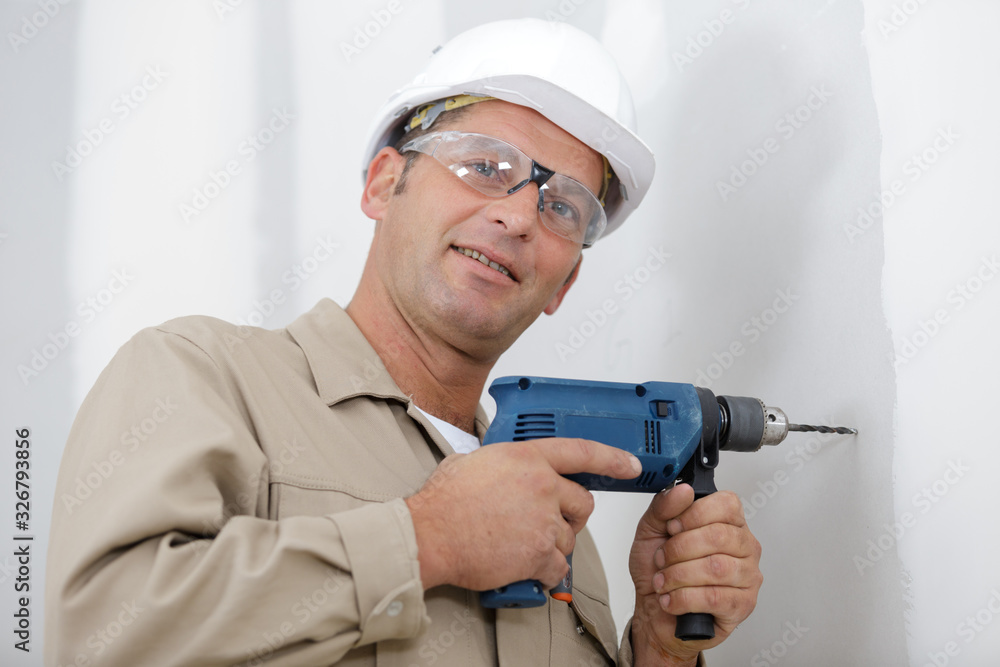 man drilling the wall with drill perforator