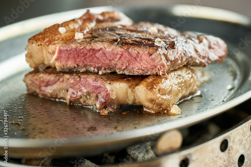 plate Grilled striploin steak. The strip steak, also called a New York strip. Serving on a wooden Board. Barbecue restaurant menu.
