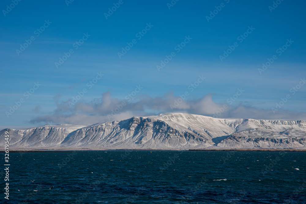 Cost line with snow covered mountains in Iceland Cost line with snow covered mountains in Iceland