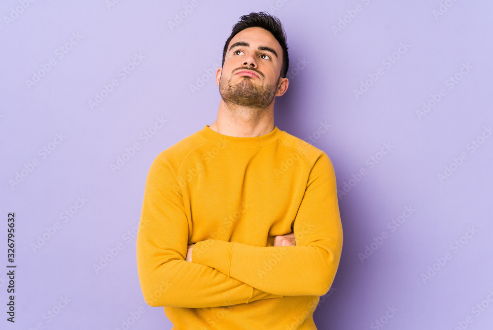 Young caucasian man isolated on purple background tired of a repetitive task. Young caucasian man isolated on purple background tired of a repetitive task.