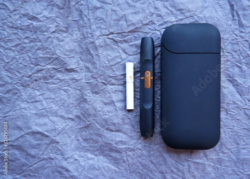 Iqos electronic cigarette on a blue background. Marlboro and Philip Morris. A new generation hybrid cigarette.