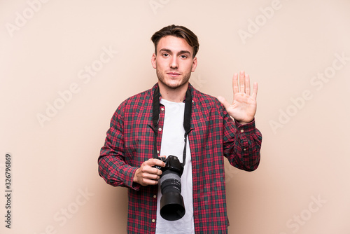 Young caucasian photographer man isolated smiling cheerful showing number five with fingers.