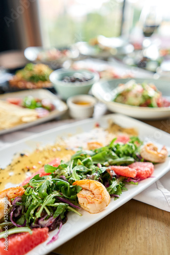 Fresh salad with grilled shrimps  slice grapefruit and arugula salad and spicy fried prawns. Restaurant menu  natural and organic food concept.