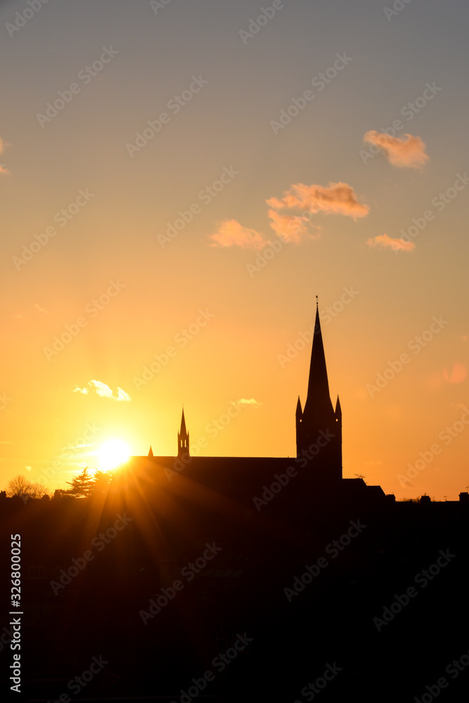 Fototapeta premium Church building exterior in silhouette of sunrise or sunset with glowing sunlight