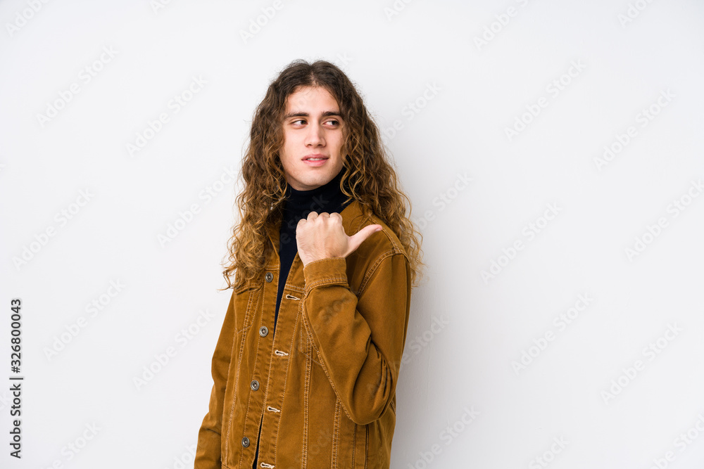 Long hair man posing isolated points with thumb finger away, laughing and carefree. Long hair man posing isolated points with thumb finger away, laughing and carefree.