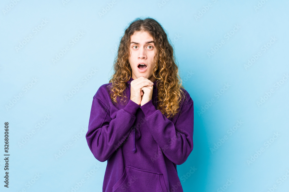 Long hair man posing isolated praying for luck, amazed and opening mouth looking to front. Long hair man posing isolated praying for luck, amazed and opening mouth looking to front.