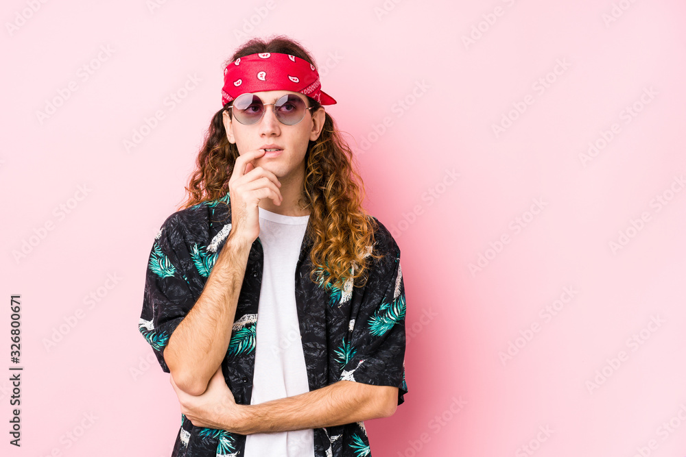Young hippie caucasian man isolated relaxed thinking about something looking at a copy space.