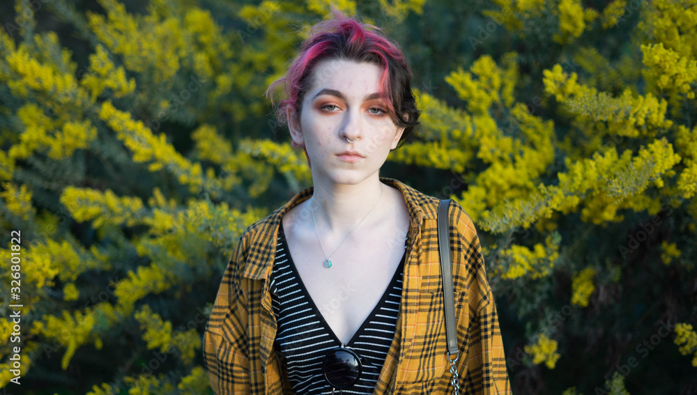 hipster emo girl wearing a yellow flannel with yellow plants behind her hipster emo girl wearing a yellow flannel with yellow plants behind her