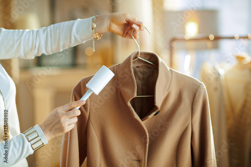 Принти на полотні Closeup on female cleaning coat on hanger with lint roller