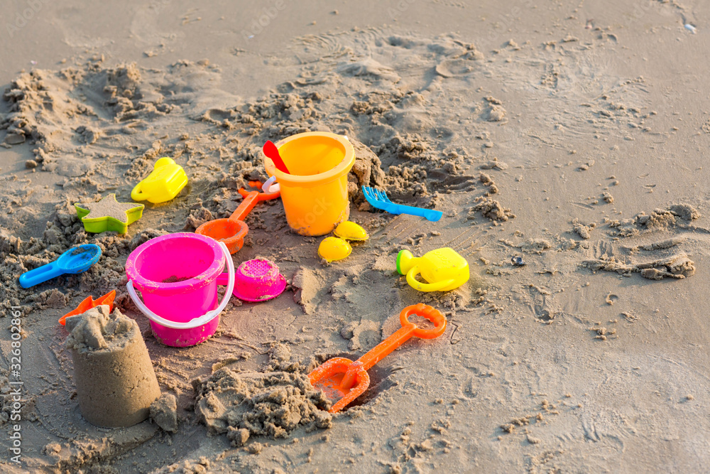 Plastic sandbox toys on the sand. kids toys on tropical sand beach. Plastic shovel and sea animal mold toys on sand. Favorite toys for kids activity on beach sand. Vacation image of children beach toy Plastic sandbox toys on the sand. kids toys on tropical sand beach. Plastic shovel and sea animal mold toys on sand. Favorite toys for kids activity on beach sand. Vacation image of children beach toy