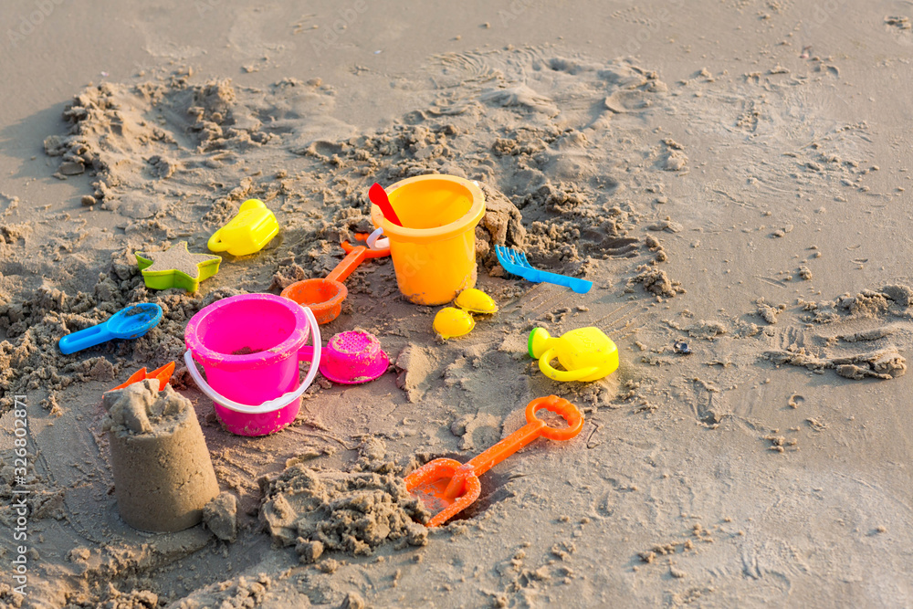 Plastic sandbox toys on the sand. kids toys on tropical sand beach. Plastic shovel and sea animal mold toys on sand. Favorite toys for kids activity on beach sand. Vacation image of children beach toy Plastic sandbox toys on the sand. kids toys on tropical sand beach. Plastic shovel and sea animal mold toys on sand. Favorite toys for kids activity on beach sand. Vacation image of children beach toy