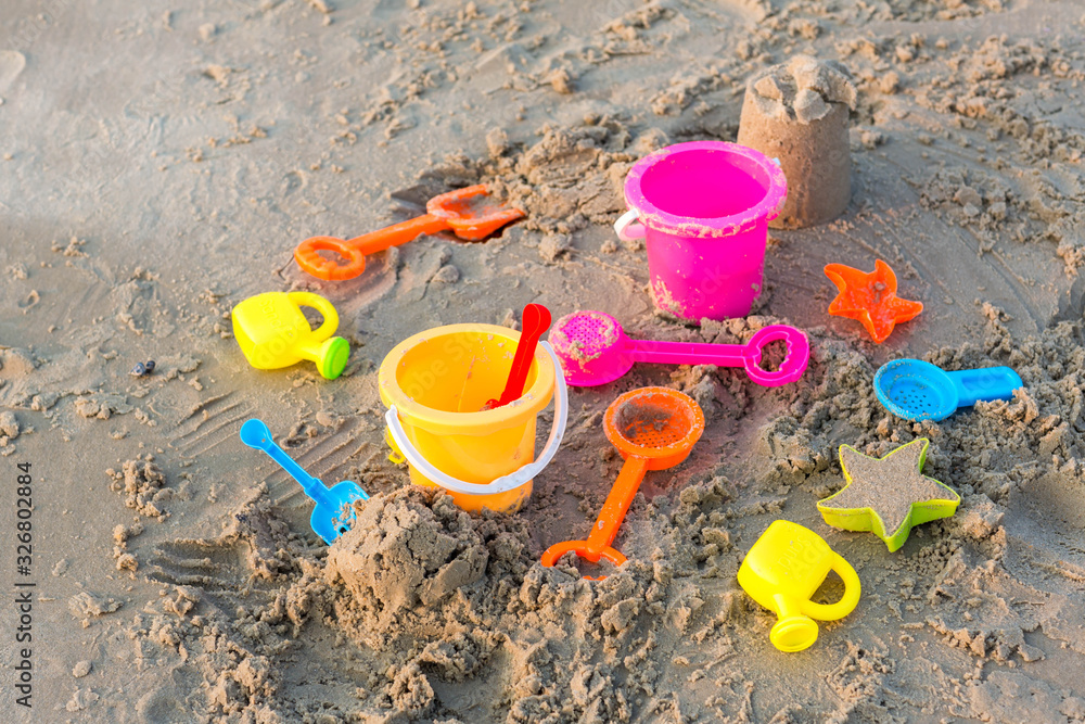 Plastic sandbox toys on the sand. kids toys on tropical sand beach. Plastic shovel and sea animal mold toys on sand. Favorite toys for kids activity on beach sand. Vacation image of children beach toy Plastic sandbox toys on the sand. kids toys on tropical sand beach. Plastic shovel and sea animal mold toys on sand. Favorite toys for kids activity on beach sand. Vacation image of children beach toy