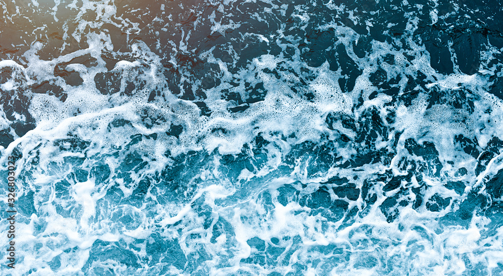 Background shot of aqua sea water waves surface. Blue ocean water and foam aerial view.