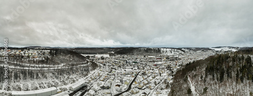 Albstadt panorama from above, snow city at the Schwaebische Alb of germany in white powdered winter landscape aerial scene from a drone. photo