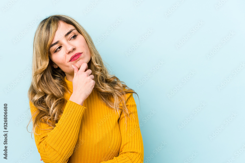 Young blonde caucasian woman looking sideways with doubtful and skeptical expression. Young blonde caucasian woman looking sideways with doubtful and skeptical expression.