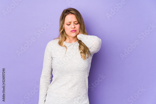 Young caucasian woman isolated on purple background suffering neck pain due to sedentary lifestyle.