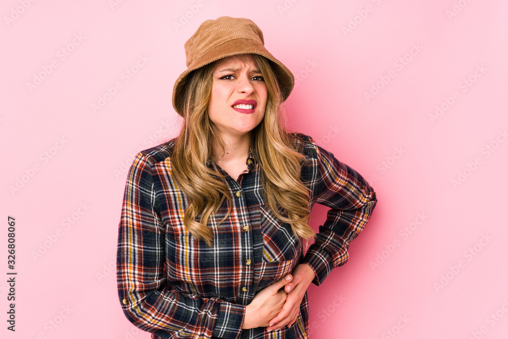 Young caucasian woman wearing a hat isolated having a liver pain, stomach ache. Young caucasian woman wearing a hat isolated having a liver pain, stomach ache.
