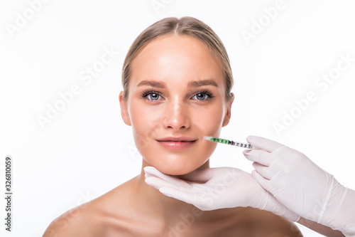 Closeup of beautiful woman gets injection in her lips isolated over white background